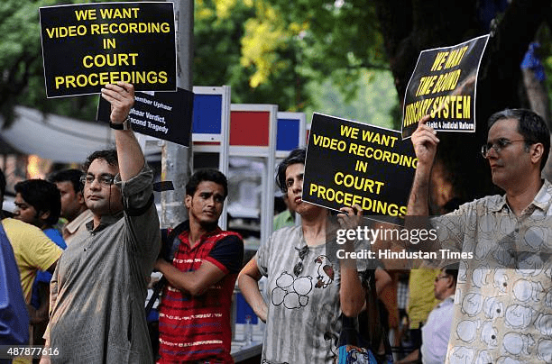 Bereaved families of Uphaar Cinema fire victims protesting outside court, challenging powerful owners and systemic delays in their pursuit of justice.