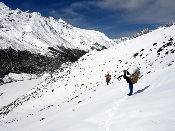 Snowfall covering Himalayan mountain roads in India during winter.