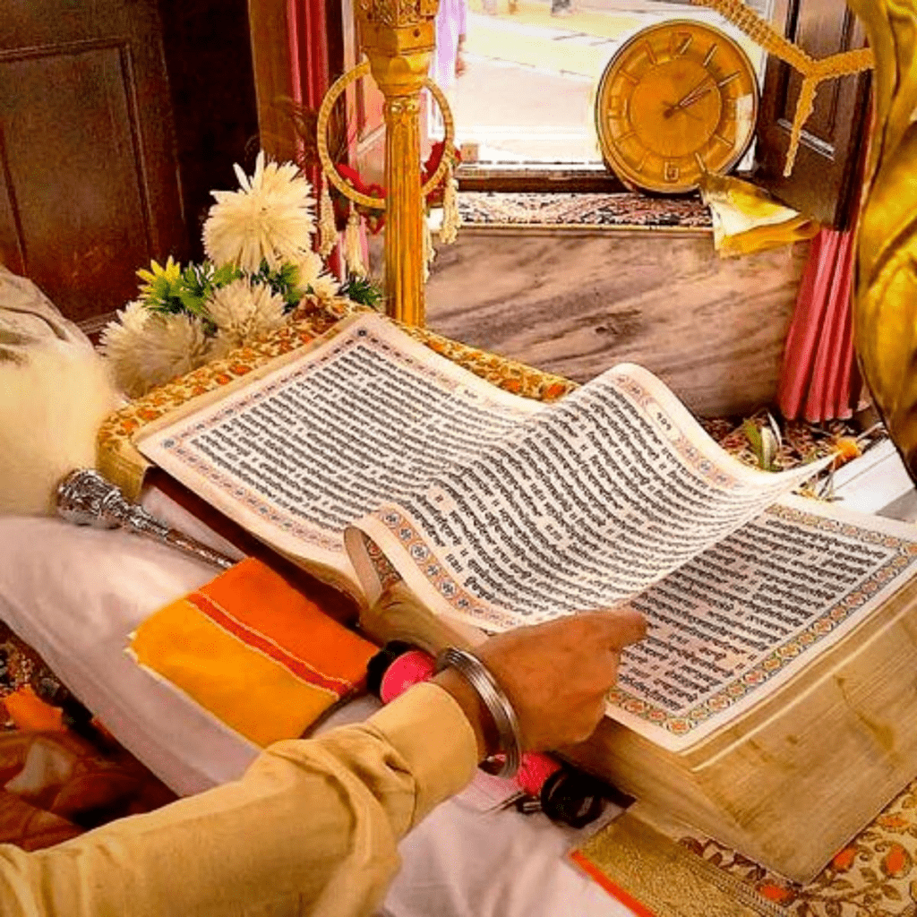 Hands turn Guru-Granth-Sahib pages, daily guidance rooted in Nanak’s compassion-centered teachings today.