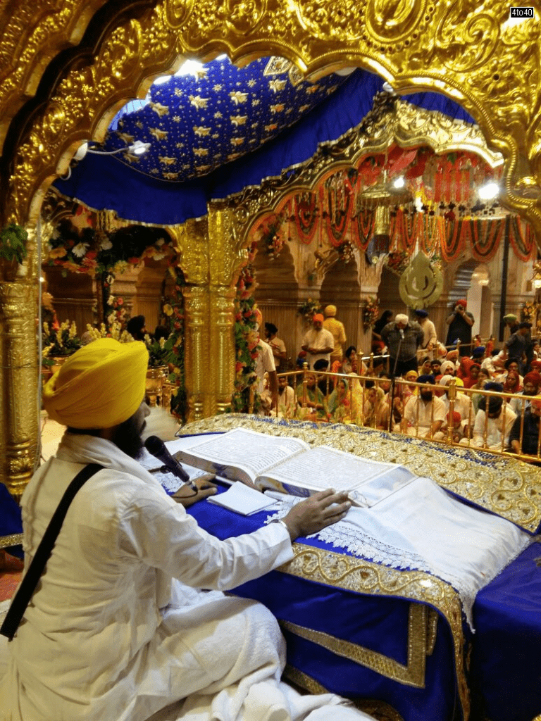 Reading Guru Granth Sahib inside gurdwara symbolizing equality universal compassion and shared humanity